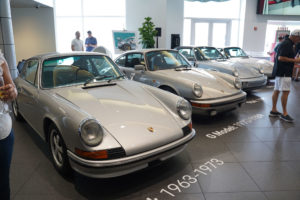 four silver porsche vehicles in a row at the september rise and drive event at the collection